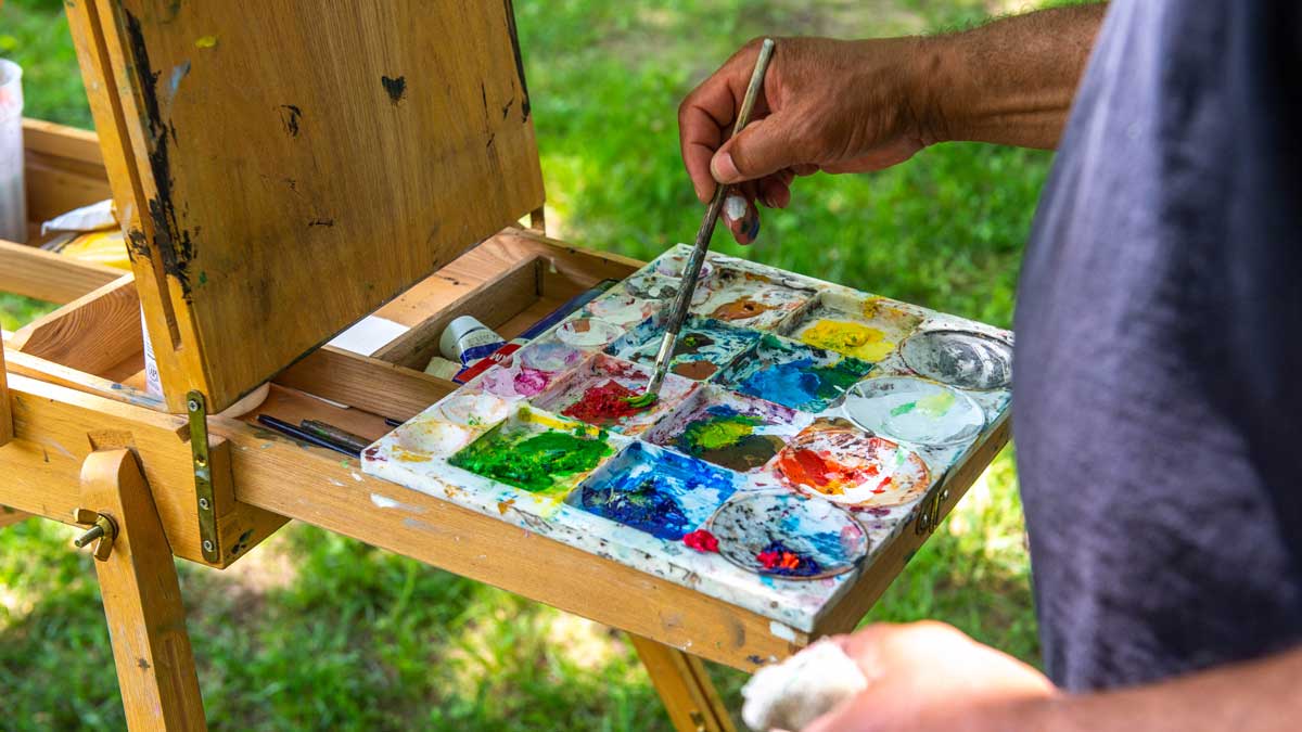 A person is painting while on campus.