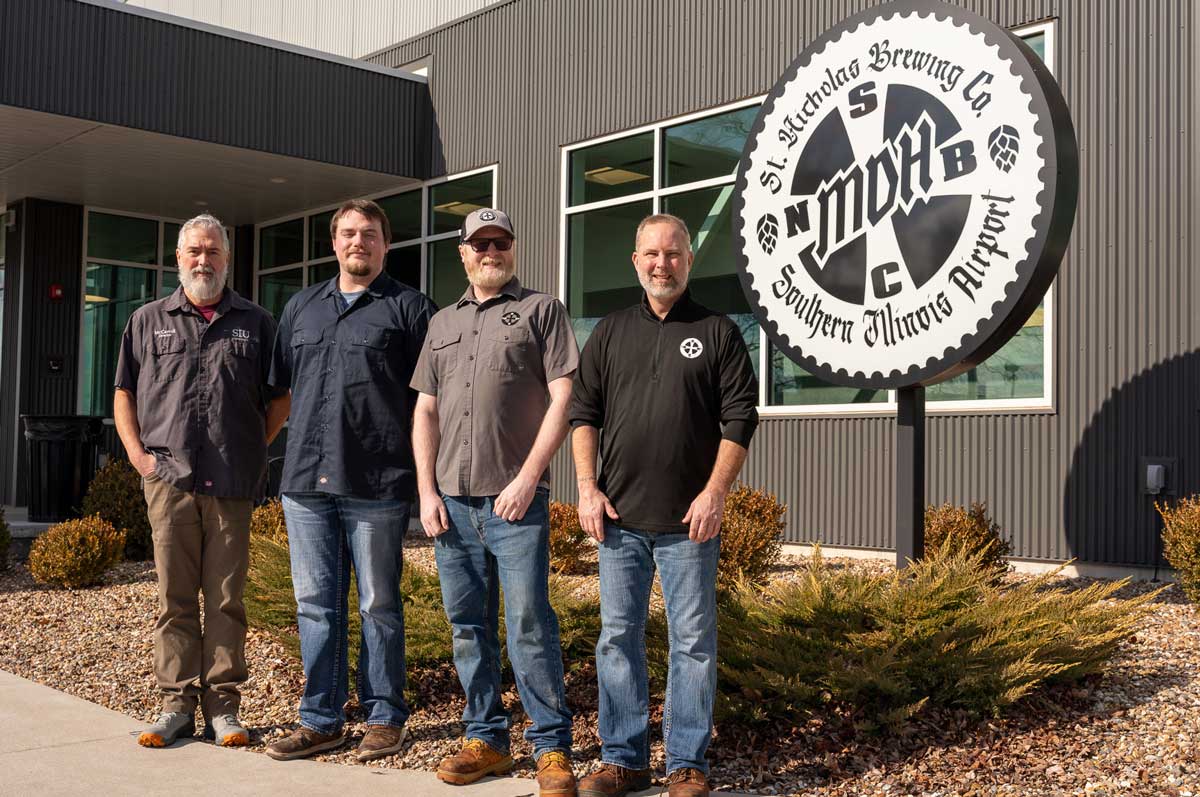 Four men stand outside of St. Nicholas Brewing Company.