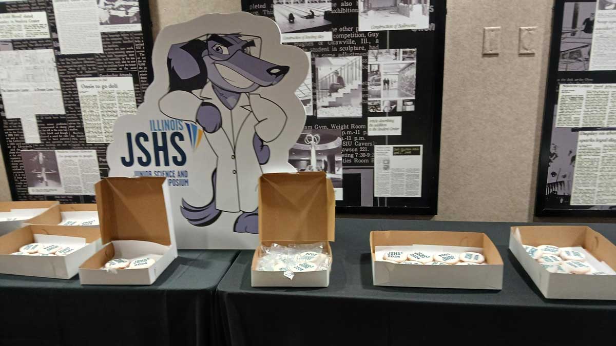 A table displaying a sign and cookies for an event.