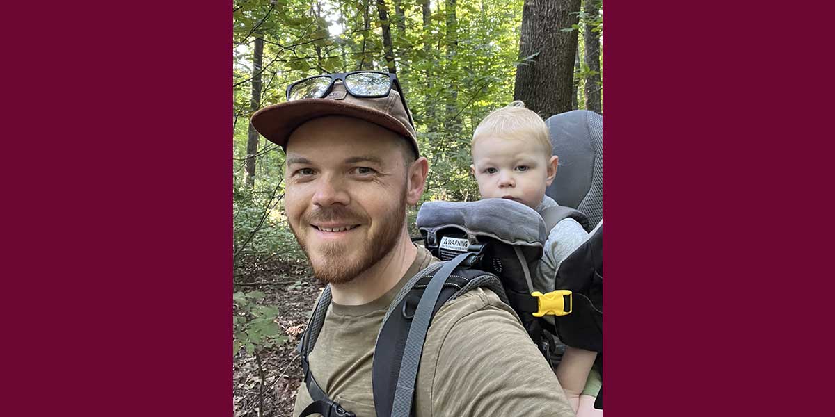 A man with a baby in a backpack carrier.