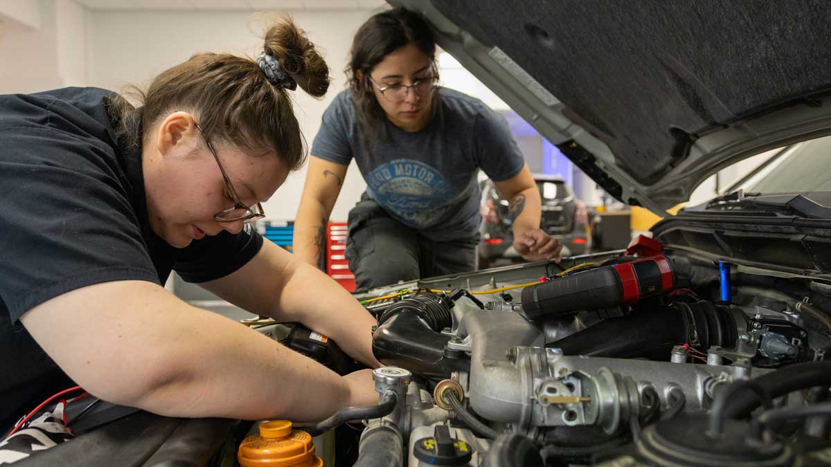 Women working on a car engine.