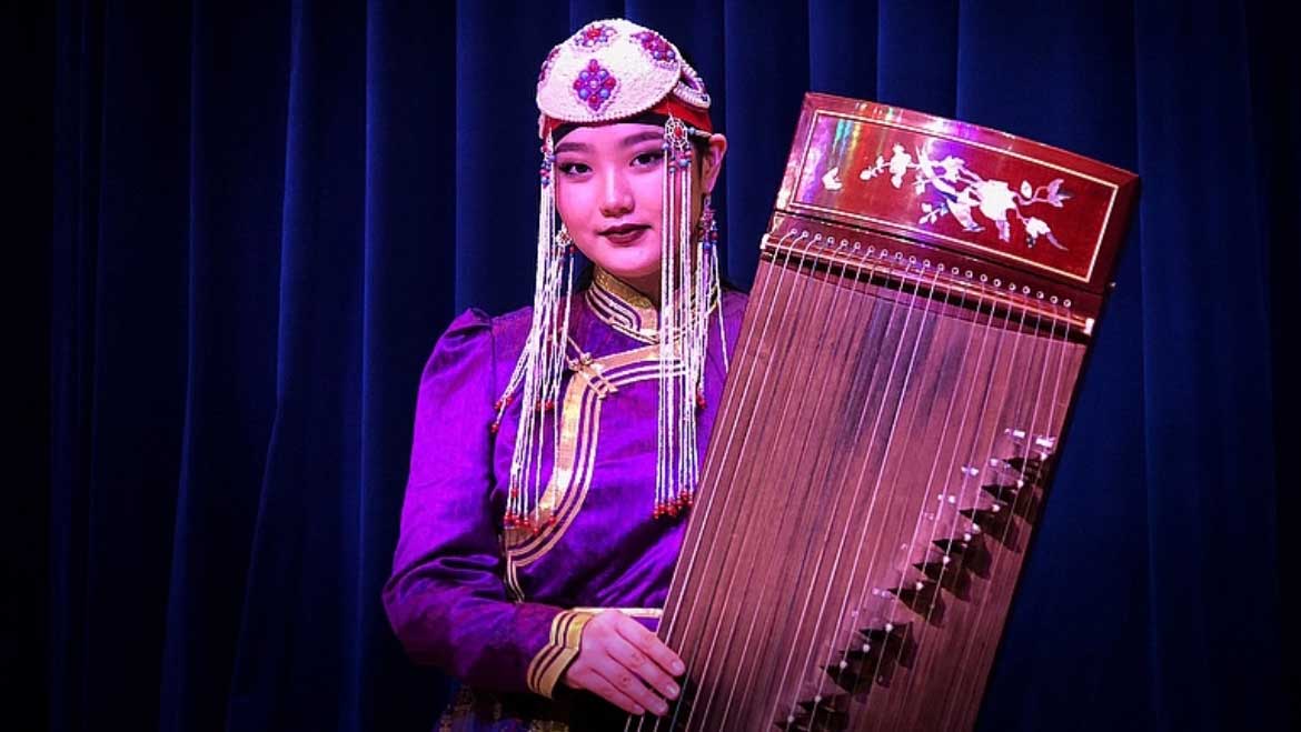 A woman holding a Mongolian harp.