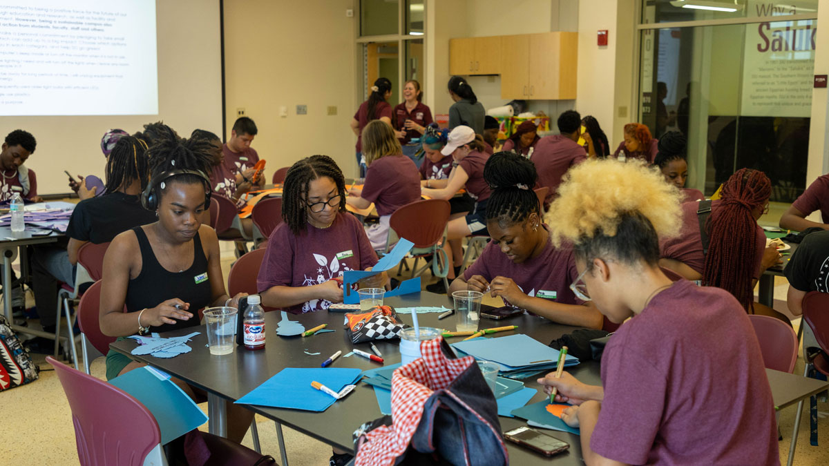 Young people working on a project while seated at a table.