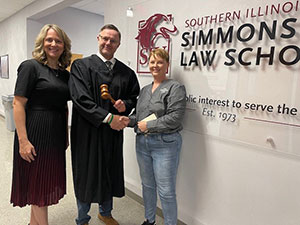 A judge is presenting a ceremonial gavel to the law school.