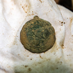 A small medallion found in the dirt.