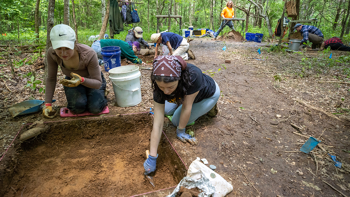 A woman digging in the dirt.