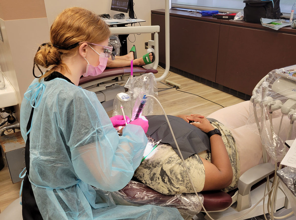 A dental student provides patient care.