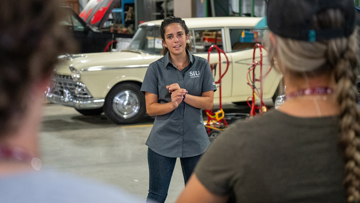 A woman gives instruction during an automotive class.