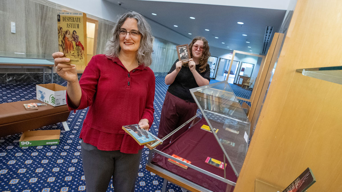 Two women work on a display of books highlighted during Banned Books Week.