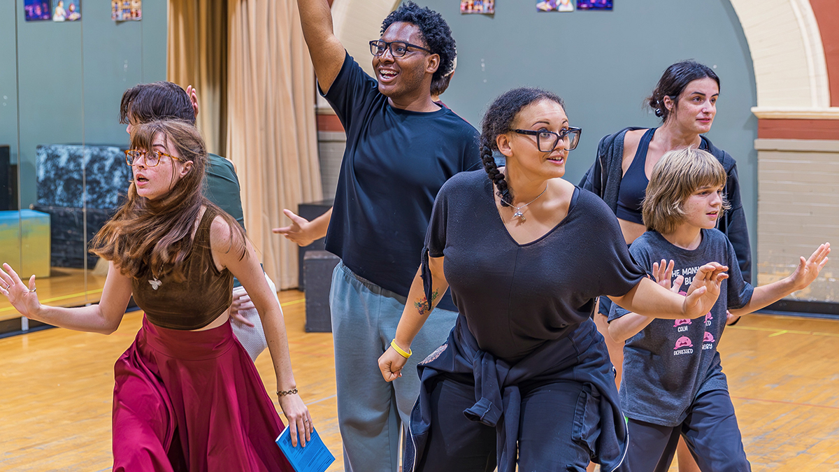 Cast members rehearse a play.