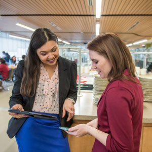 Two students talking in the dining hall.