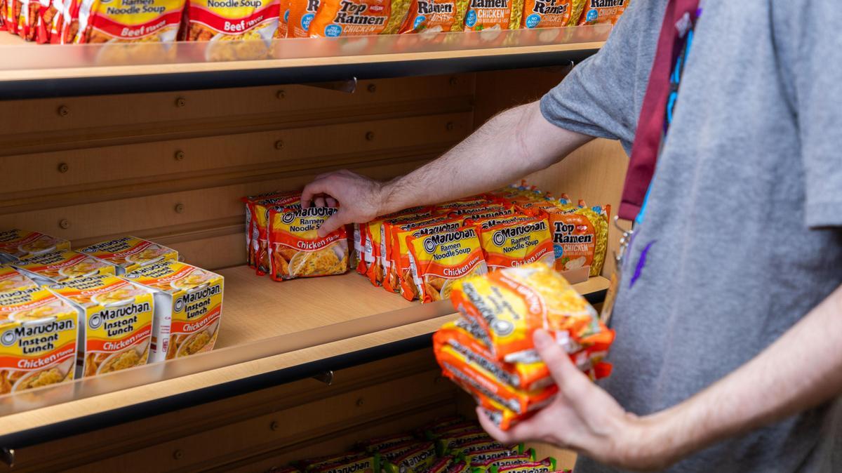 A person is stocking shelves at a food pantry.