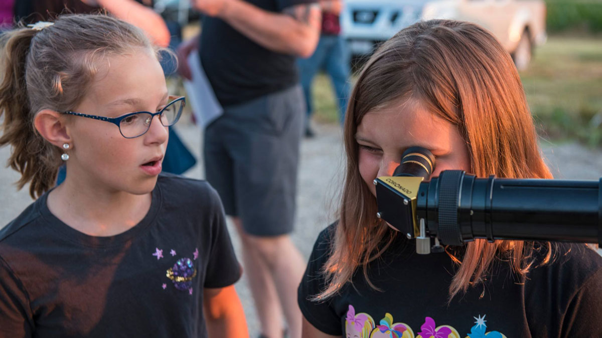Children looking through a telescope.