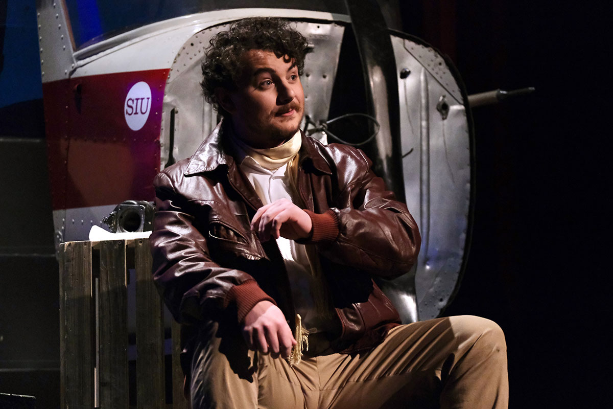 A man, on stage, performing an opera.