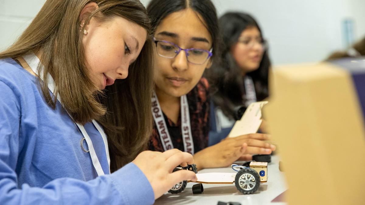 Participants work on building a robotic car.