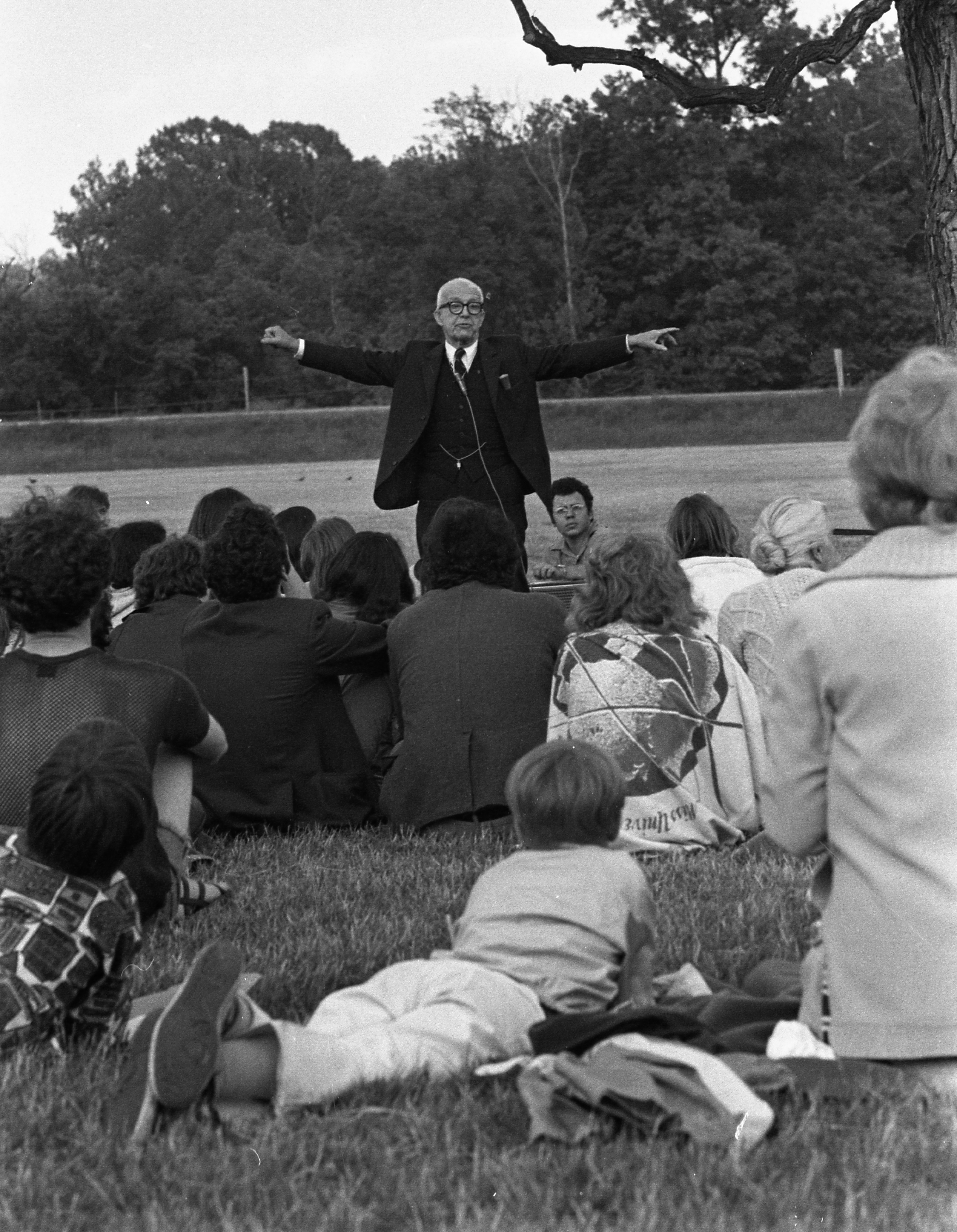 R. Buckminster Fuller speaking to a group of people seated on the grass.