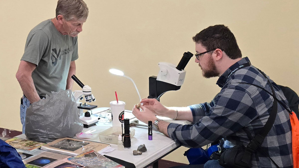 An SIU student examines a rock at last year's rock and mineral clinic.