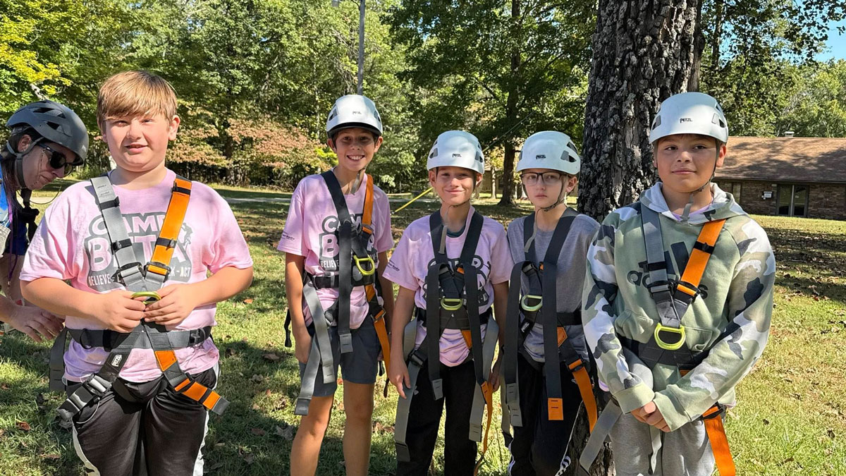 Participants are putting on safety gear as they prepare for an activity.
