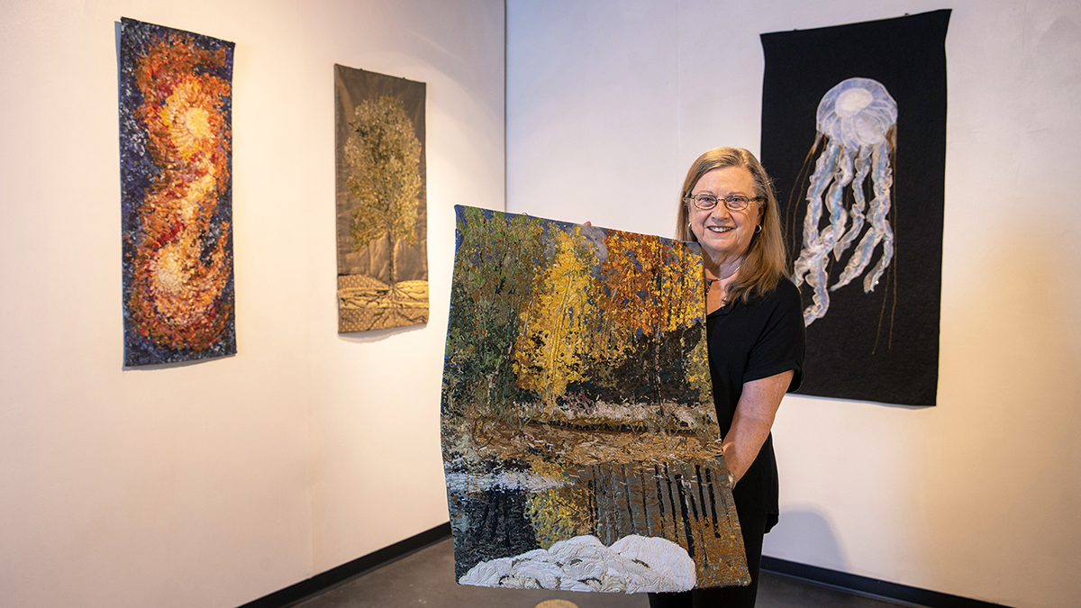 Dawn Murtaugh shows off a piece of art she created using recycled fabrics.
