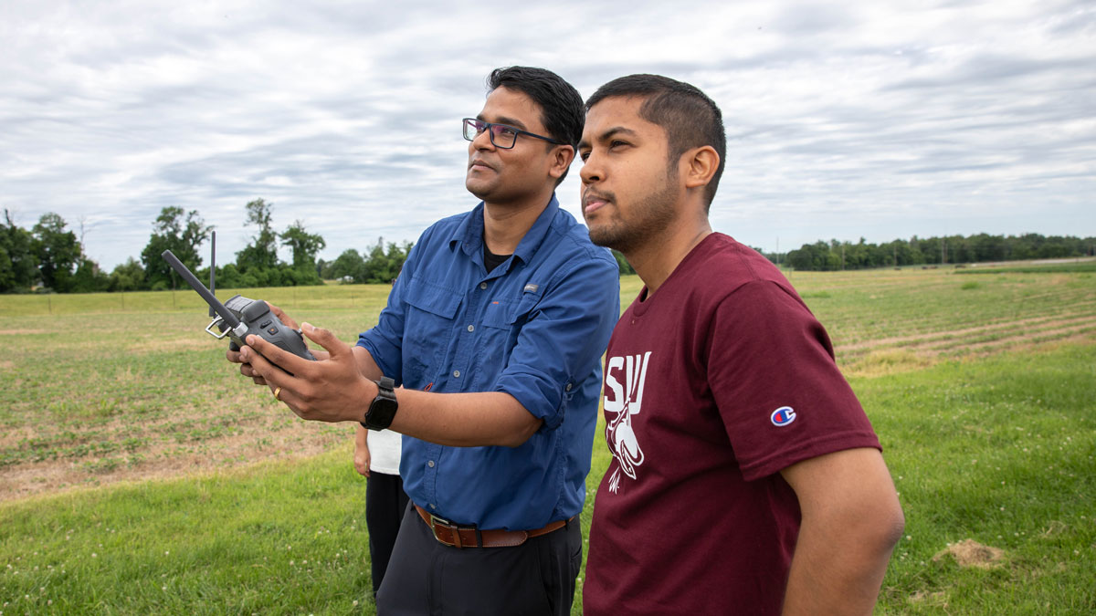 A professor and graduate student operate a drone demonstration.