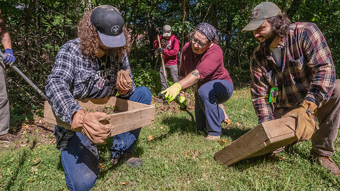 Researchers examine dirt content as they screen the soil.
