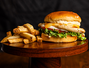 A plate of food consisting of french fries and a chicken sandwich.