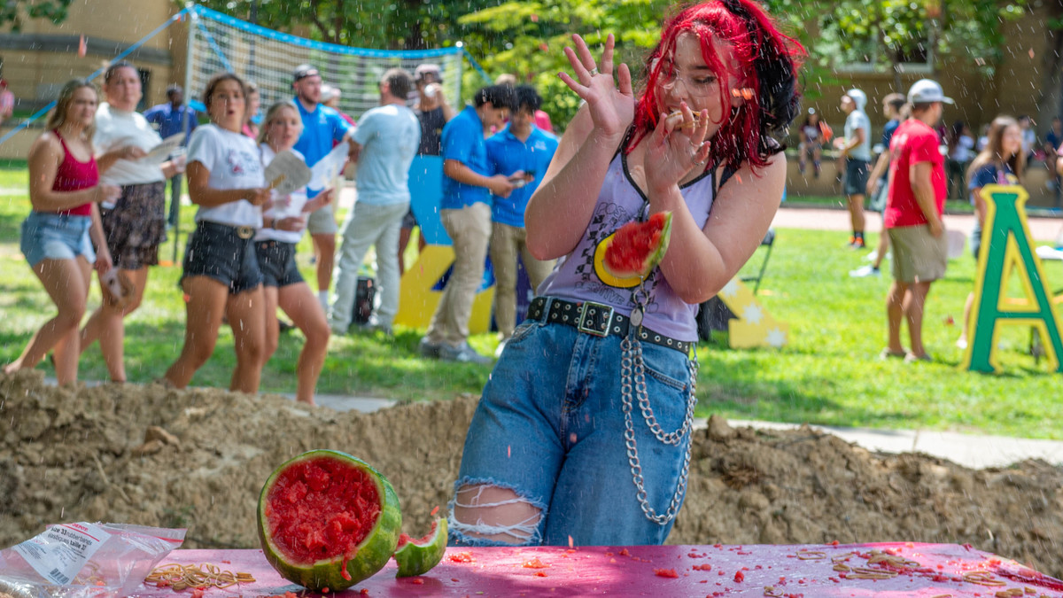 A student discovers what happens when rubber bands are applied to a watermelon as pieces fly all around.