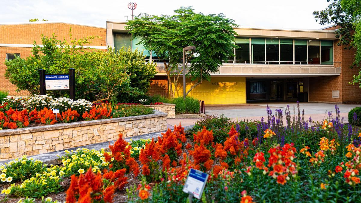 SIU Carbondale Agriculture building with flowers blooming in the foreground.