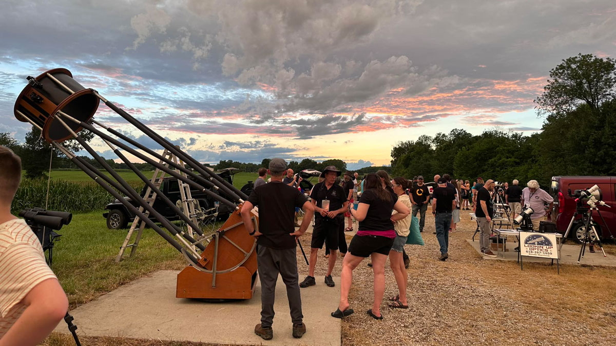 Participants prepare to view the night sky through a large telescope.