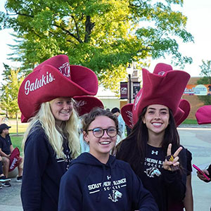 SIU students show school spirit by wearing oversized, maroon hats that say Salukis.