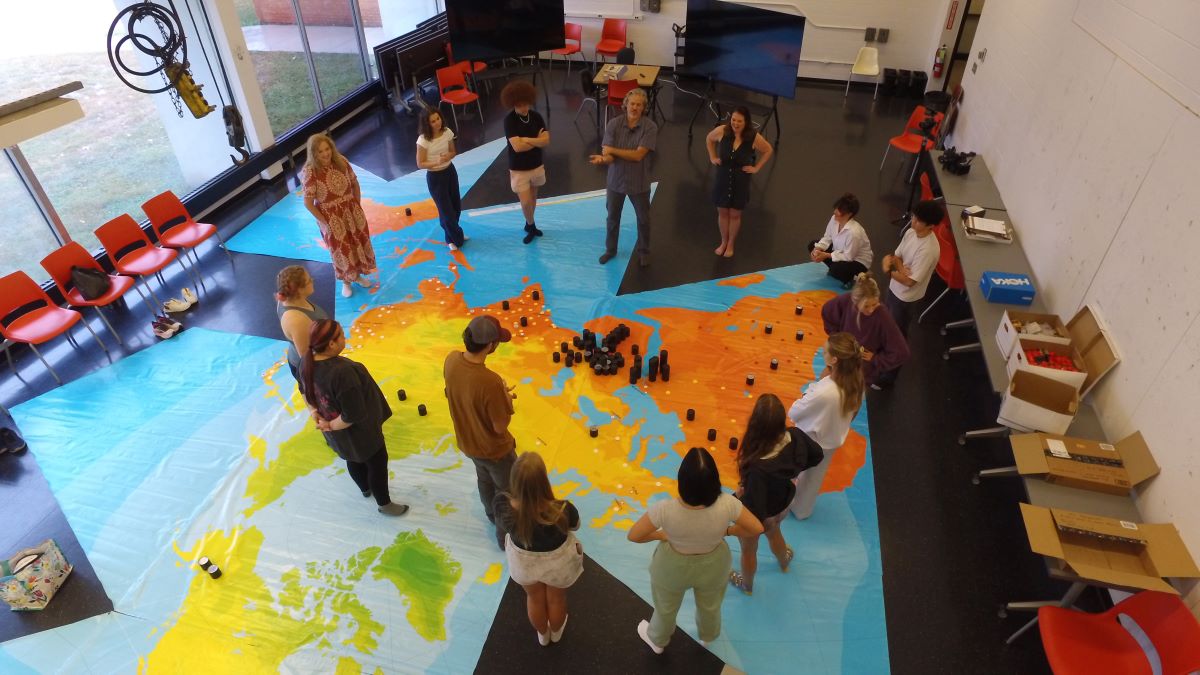 Students gathered around a dymaxion map